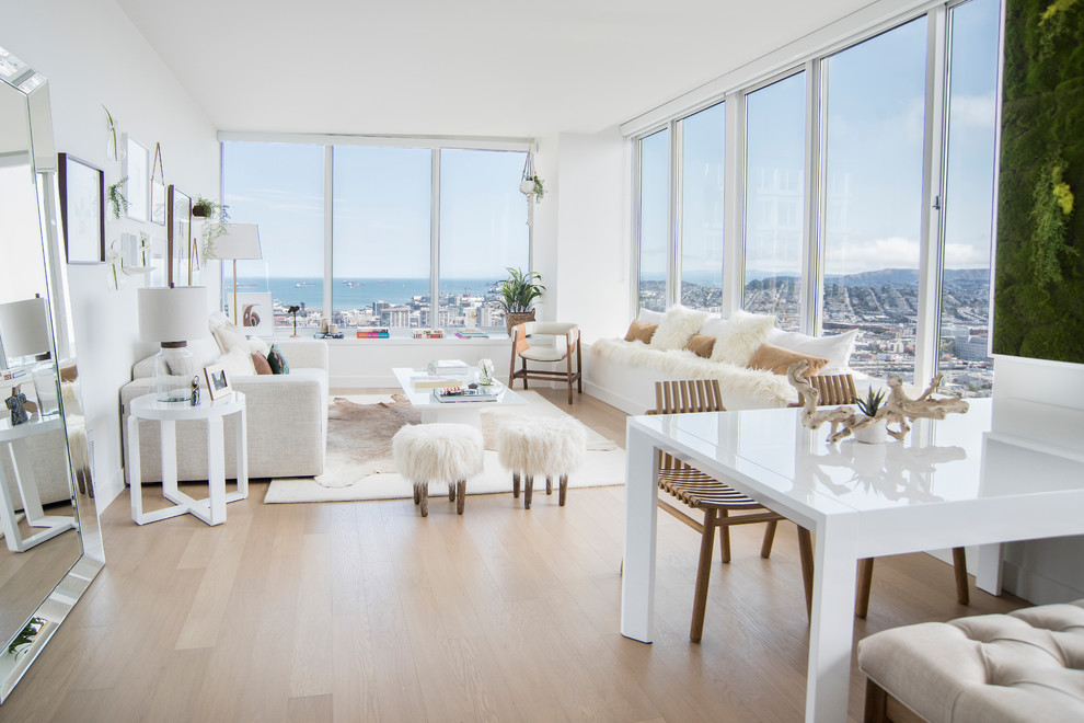 Modelo de salón para visitas abierto escandinavo de tamaño medio sin chimenea y televisor con paredes blancas, suelo de madera clara y suelo beige