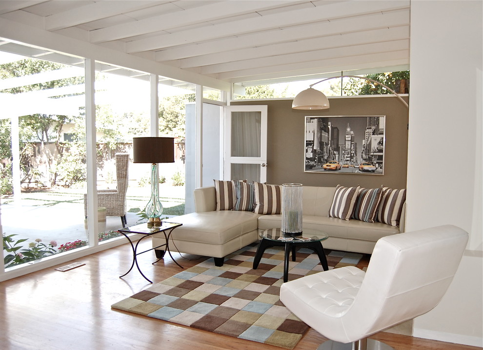 Foto de salón actual de tamaño medio con suelo de madera en tonos medios y alfombra