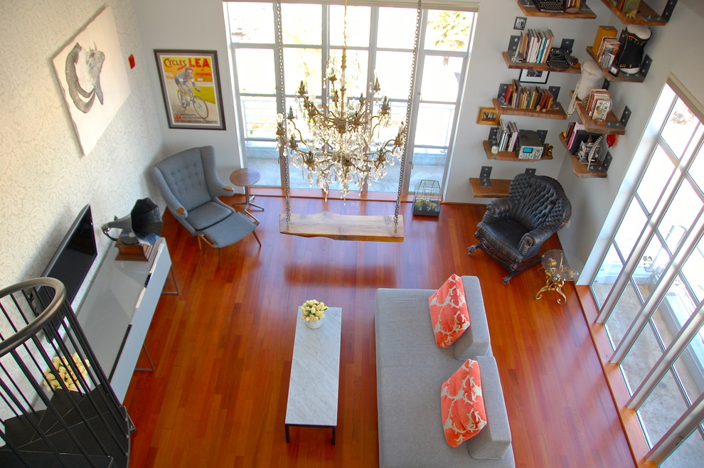 Example of a mid-sized eclectic loft-style medium tone wood floor living room design in San Francisco with a wall-mounted tv