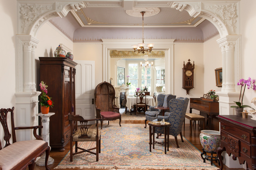 Idée de décoration pour un salon victorien fermé avec une salle de réception, un mur beige et un sol en bois brun.