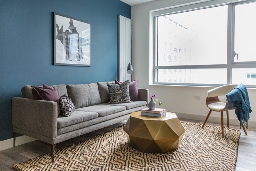 Inspiration pour un petit salon bohème ouvert avec un mur bleu, parquet clair, un téléviseur indépendant et un sol beige.