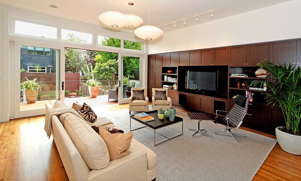 Idées déco pour un salon contemporain ouvert avec un sol en bois brun et un téléviseur encastré.