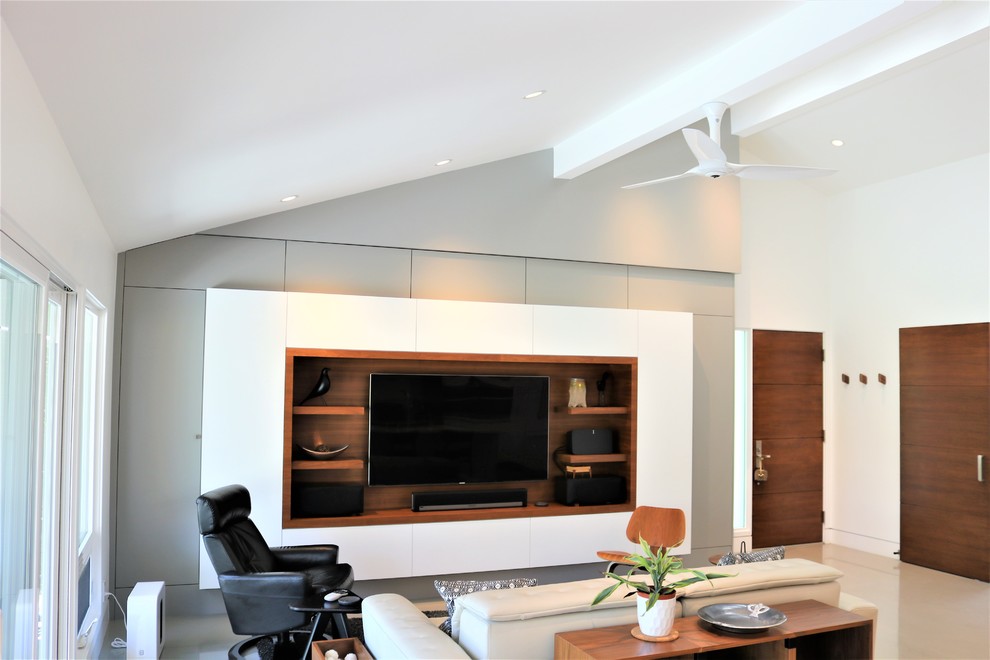 На фото: гостиная комната в современном стиле с серыми стенами, бетонным полом, мультимедийным центром и серым полом