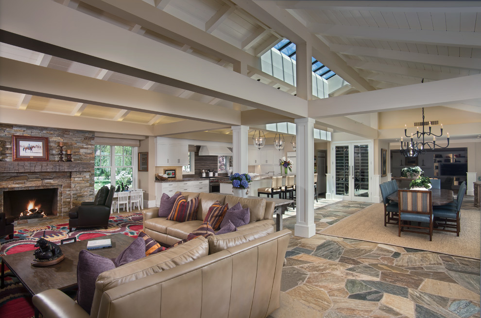 This is an example of an expansive classic open plan living room in San Diego with a standard fireplace and a stone fireplace surround.