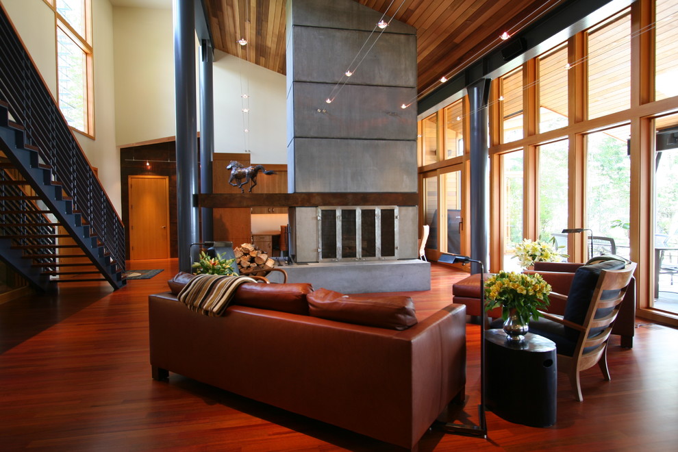 Diseño de salón contemporáneo sin televisor con suelo de madera en tonos medios, todas las chimeneas y marco de chimenea de hormigón