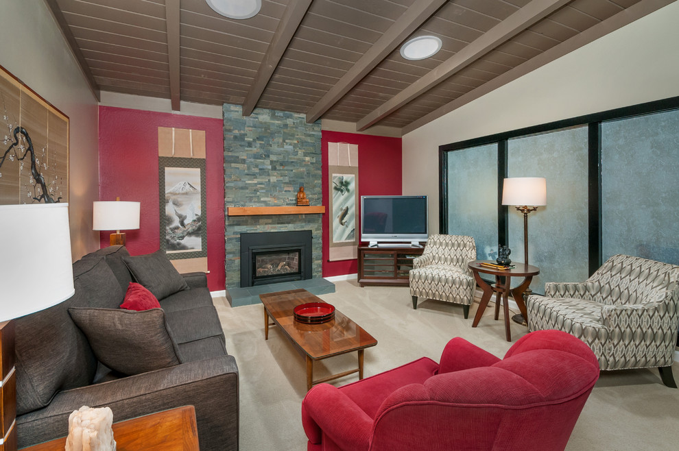 Imagen de salón de estilo zen con paredes rojas, moqueta, todas las chimeneas, marco de chimenea de piedra y televisor independiente