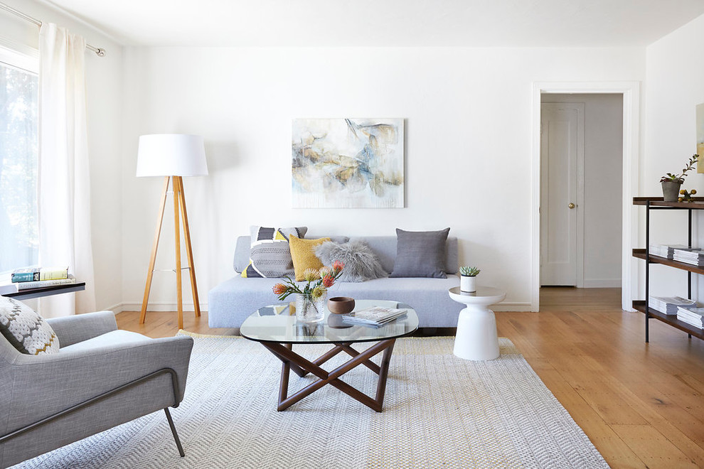 Medium sized scandi formal enclosed living room in San Francisco with white walls, light hardwood flooring, no fireplace, no tv and feature lighting.