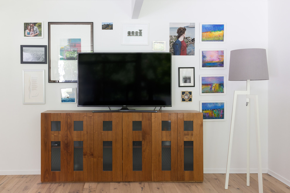 Bild på ett mellanstort retro allrum med öppen planlösning, med vita väggar, ljust trägolv, en standard öppen spis, en spiselkrans i gips, en fristående TV och gult golv