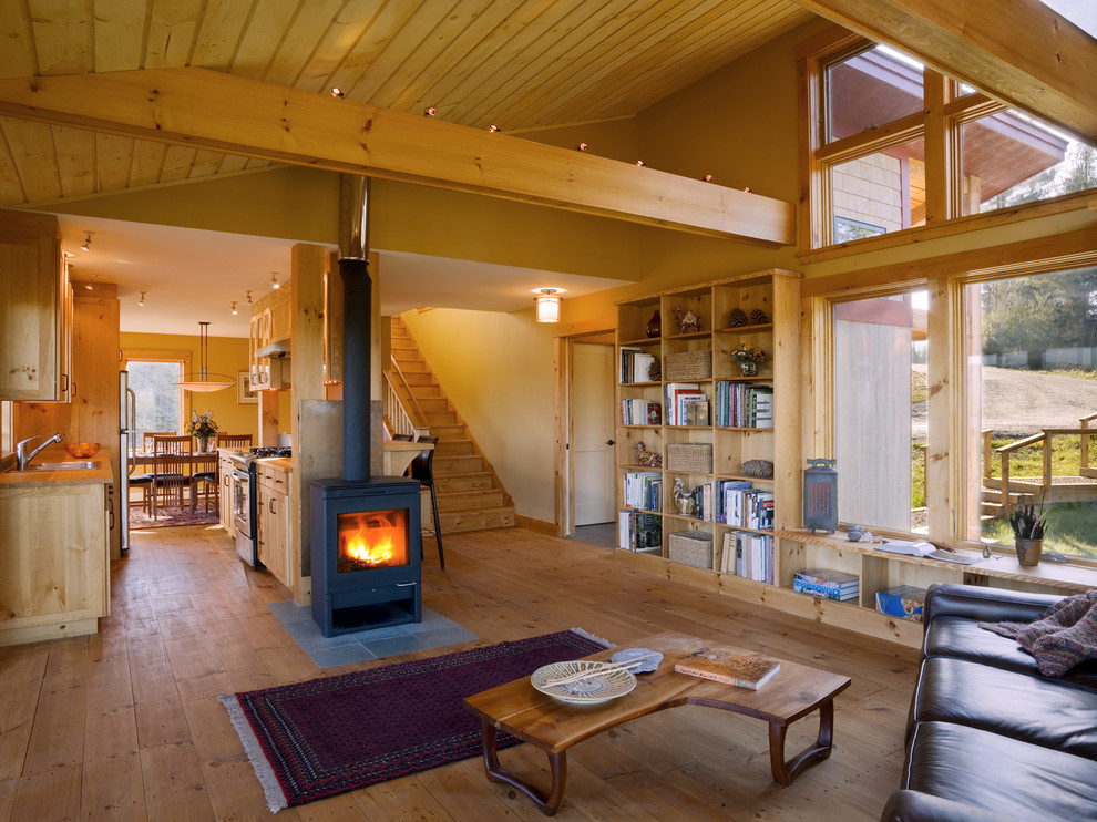 Inspiration for a rustic open plan living room in Burlington with beige walls and a wood burning stove.