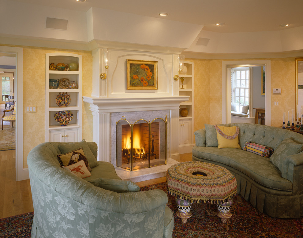 На фото: гостиная комната в морском стиле с желтыми стенами, стандартным камином и фасадом камина из камня