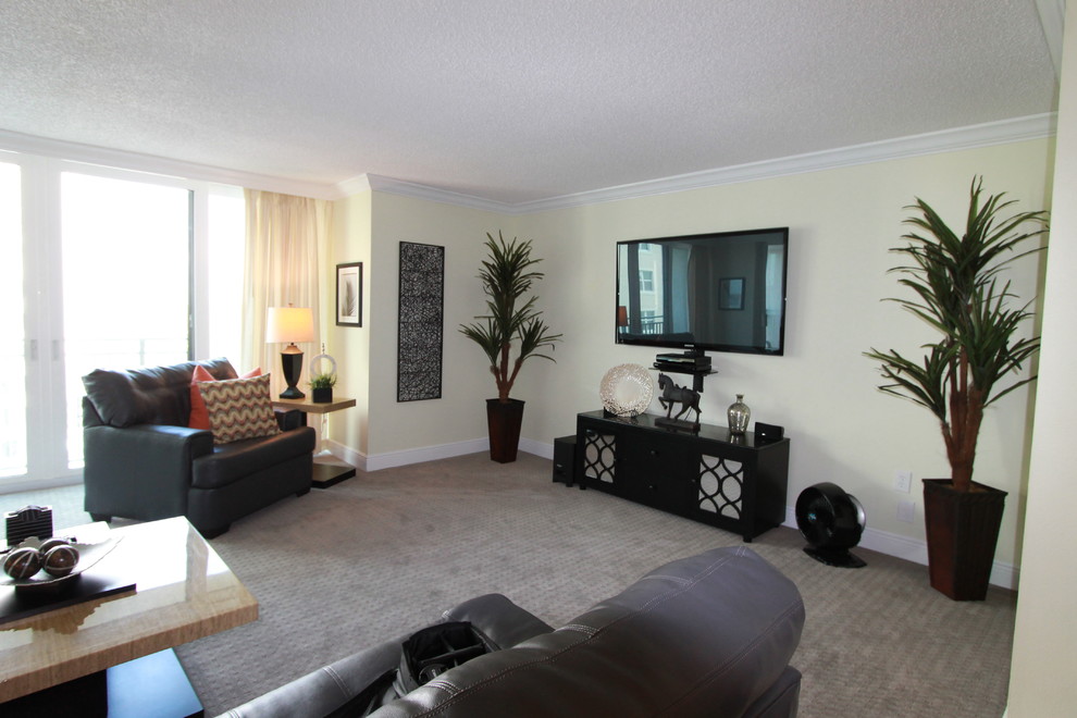 Modelo de salón abierto actual de tamaño medio con paredes verdes, suelo de baldosas de porcelana y televisor colgado en la pared