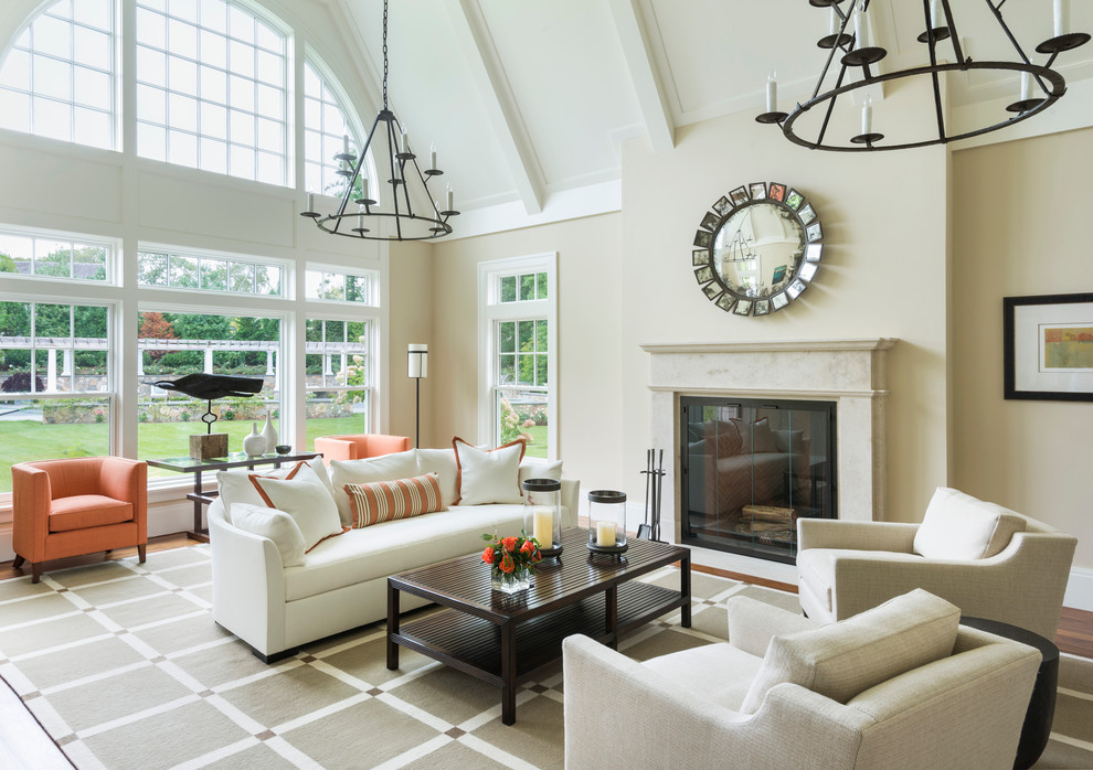 This is an example of a large traditional open plan living room in Boston with beige walls, dark hardwood flooring, a standard fireplace, a tiled fireplace surround, no tv and brown floors.
