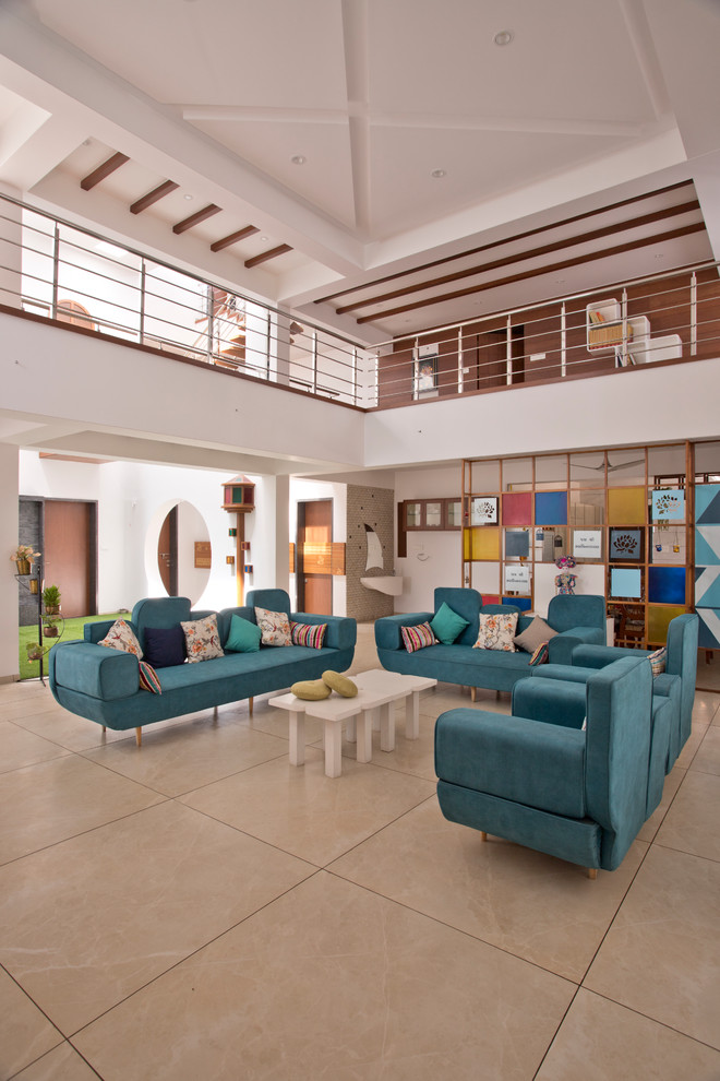 На фото: парадная гостиная комната в современном стиле с белыми стенами, бежевым полом и синим диваном с
