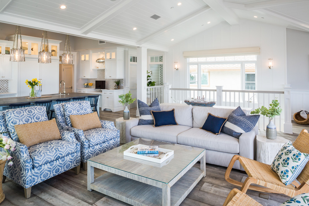 Immagine di un grande soggiorno stile marino aperto con pavimento in legno massello medio, sala formale e pareti bianche