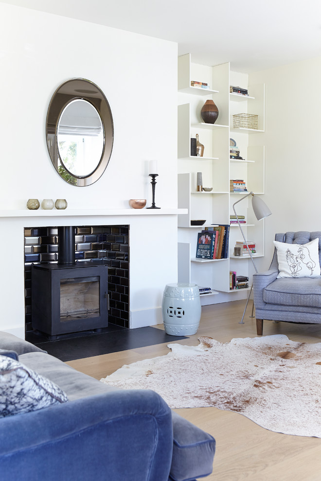Ispirazione per un soggiorno classico con pareti bianche, parquet chiaro e stufa a legna