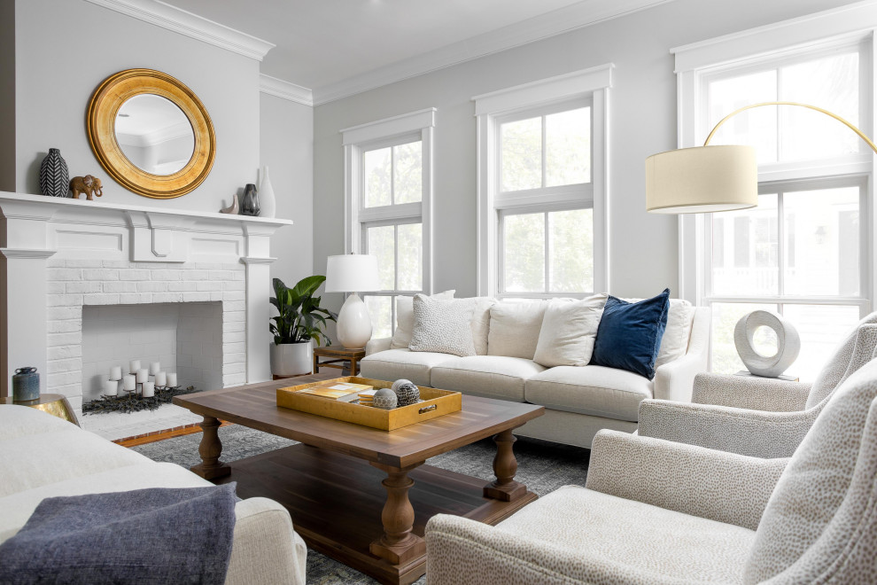 Klassisches Wohnzimmer mit grauer Wandfarbe, Kamin, Kaminumrandung aus Backstein und braunem Boden in Charleston