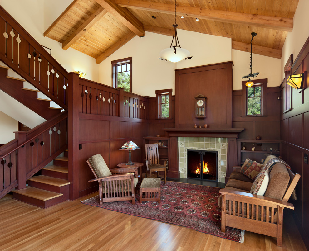 Aménagement d'un salon craftsman avec un manteau de cheminée en carrelage et un escalier.