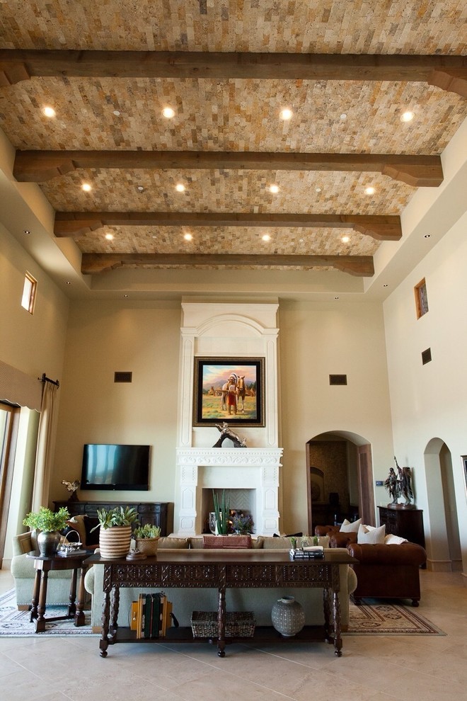 Esempio di un grande soggiorno tradizionale aperto con pareti beige, pavimento in pietra calcarea, camino classico, cornice del camino in pietra e TV a parete