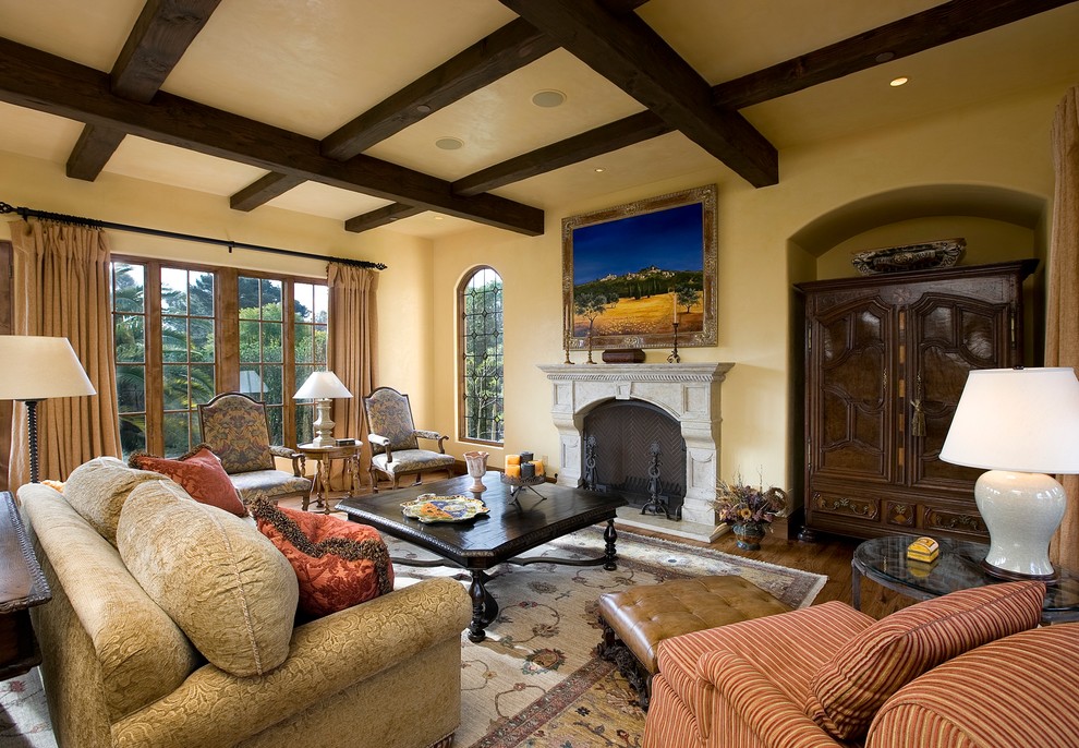 Design ideas for a mediterranean living room in Santa Barbara with yellow walls and a standard fireplace.