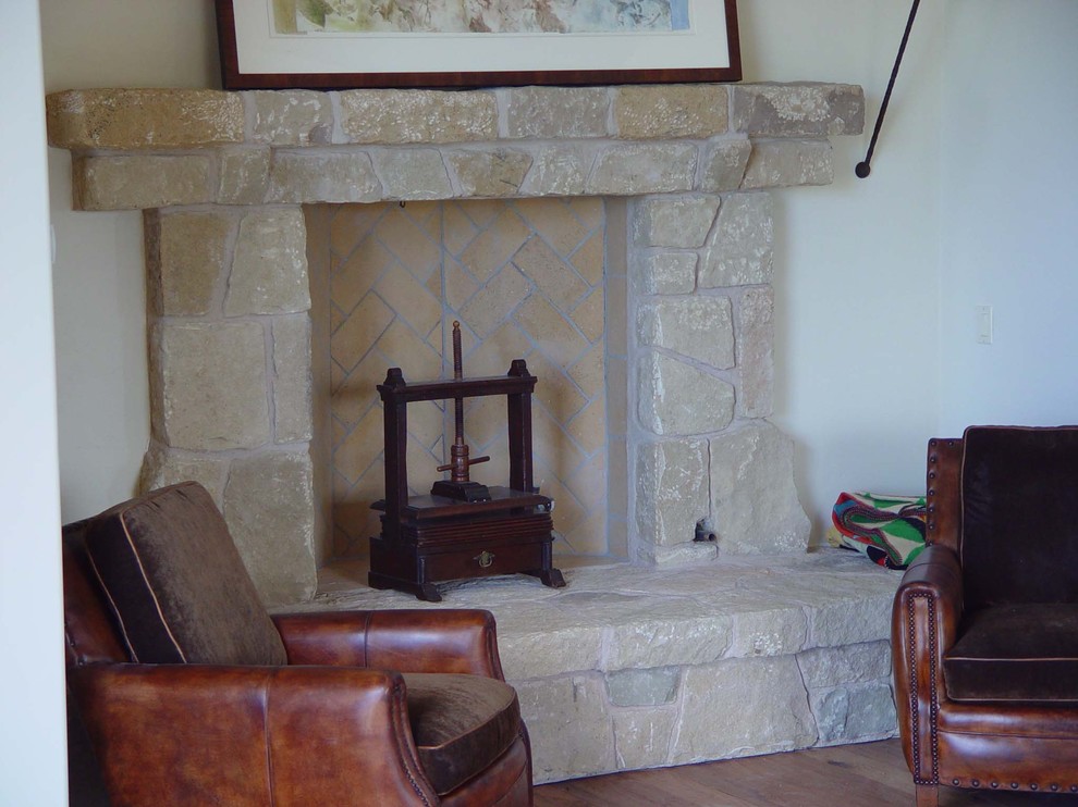 Inspiration for a mid-sized timeless formal and enclosed medium tone wood floor living room remodel in Los Angeles with white walls, a standard fireplace, a stone fireplace and no tv