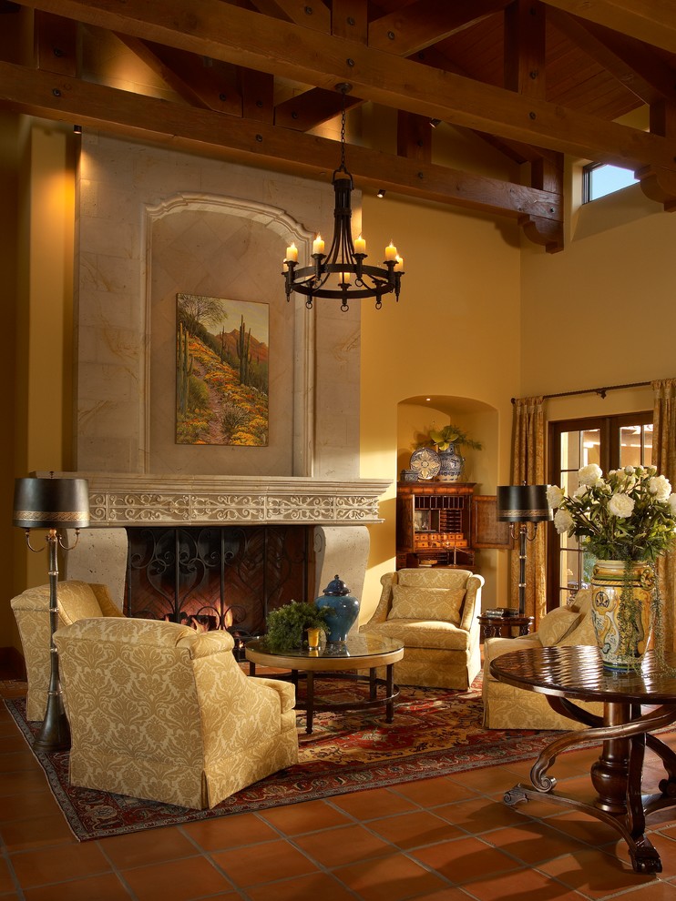 Exemple d'un grand salon méditerranéen ouvert avec une salle de réception, un mur beige, tomettes au sol, une cheminée standard, aucun téléviseur et un manteau de cheminée en pierre.