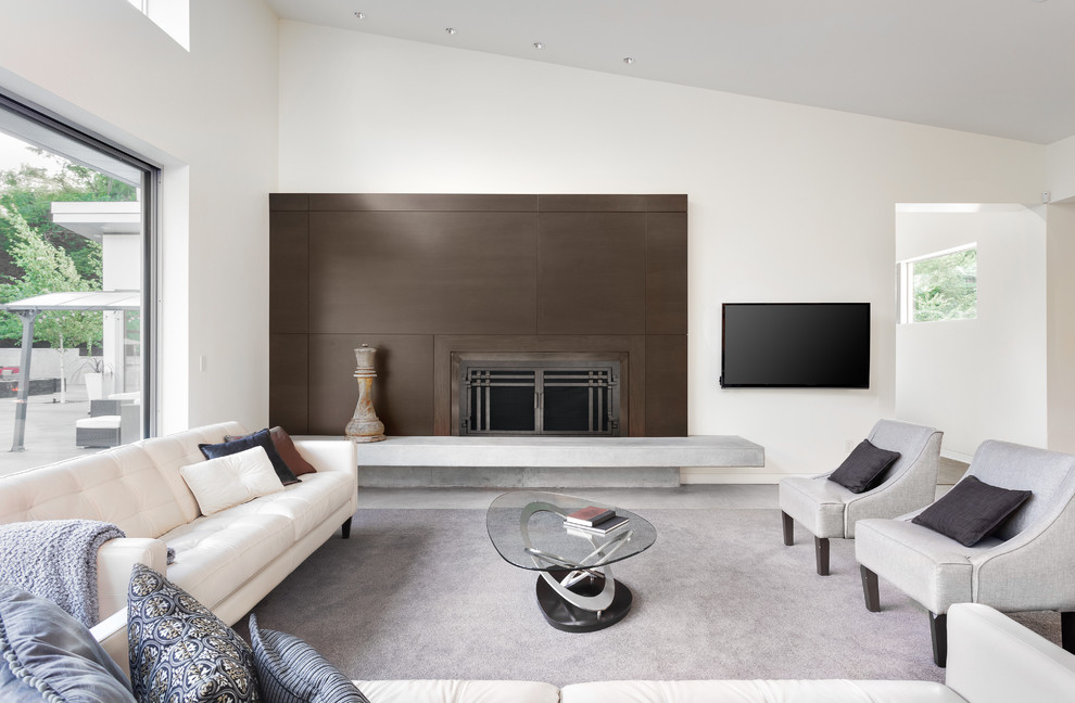 Aménagement d'un grand salon moderne ouvert avec un mur blanc, une cheminée standard, un manteau de cheminée en carrelage, un téléviseur fixé au mur et un sol blanc.