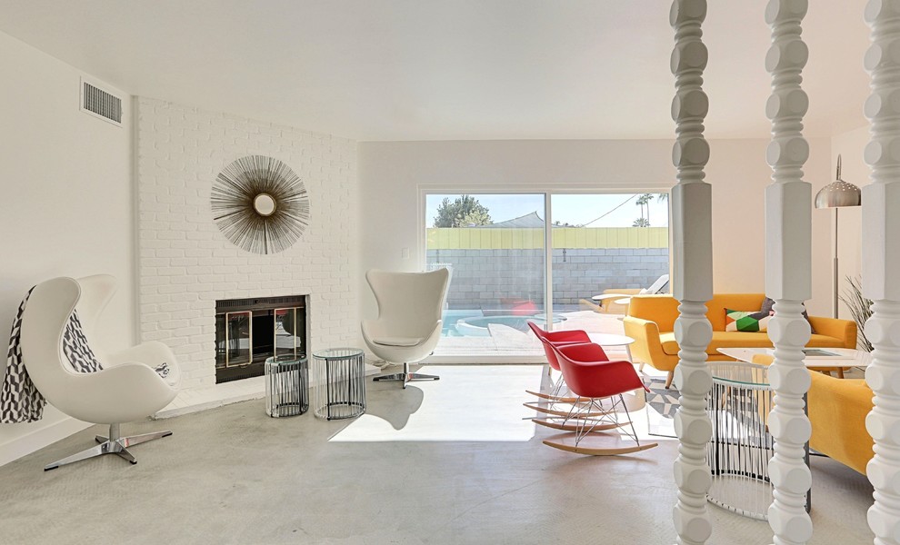 Идея дизайна: открытая гостиная комната среднего размера в стиле ретро с белыми стенами, бетонным полом, угловым камином и фасадом камина из кирпича