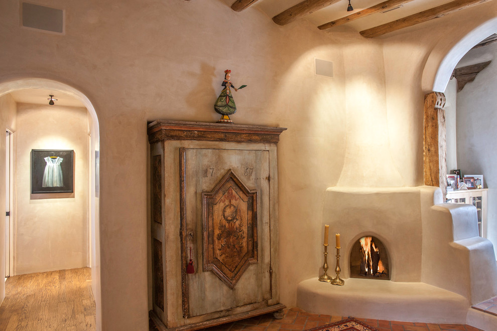 Пример оригинального дизайна: большая открытая гостиная комната в средиземноморском стиле с бежевыми стенами и кирпичным полом без камина