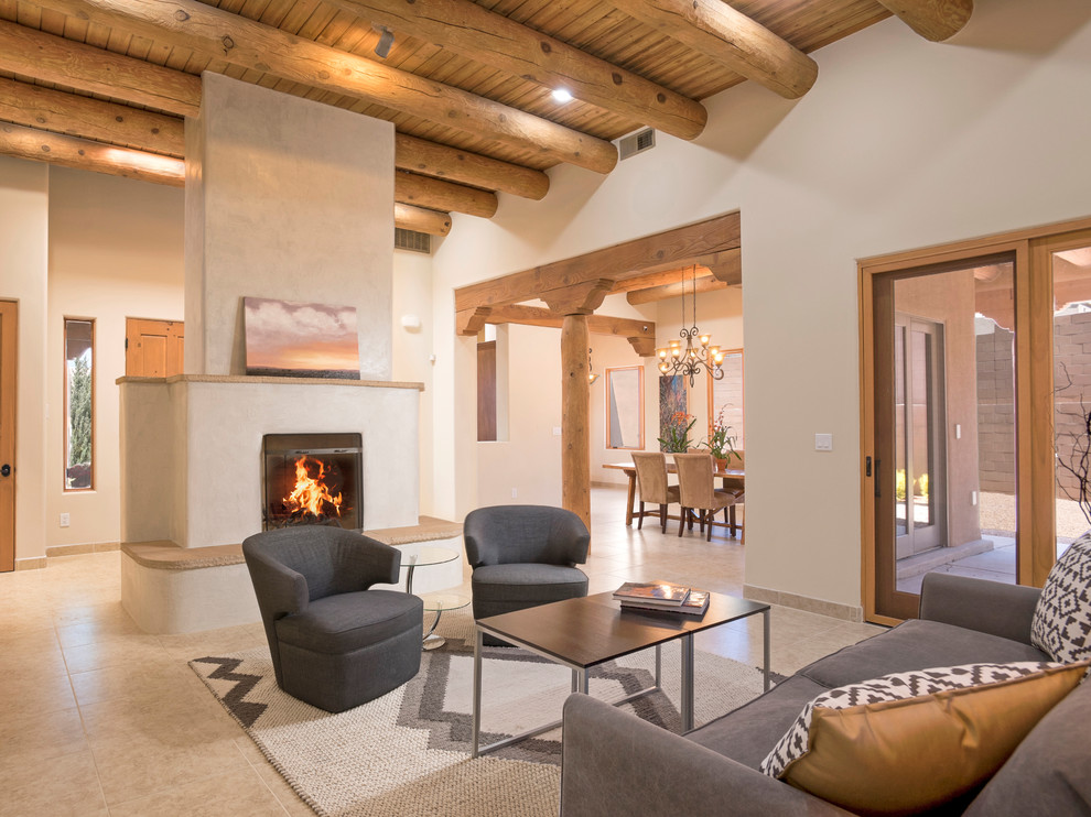 Open plan living room in Albuquerque with beige walls, a standard fireplace and beige floors.