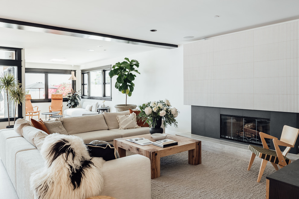 Living room - large coastal open concept light wood floor living room idea in Los Angeles with white walls, a standard fireplace and a tile fireplace
