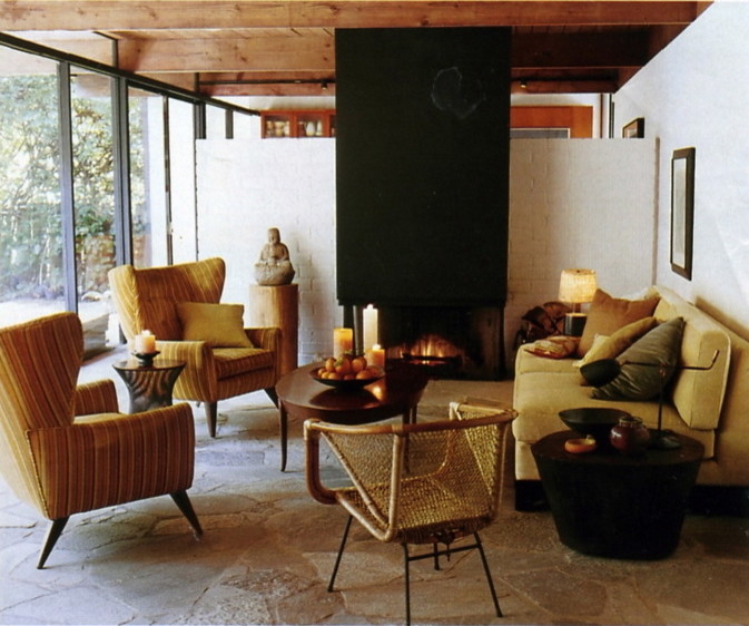 Cette photo montre un salon rétro avec un mur blanc, un sol en ardoise et cheminée suspendue.