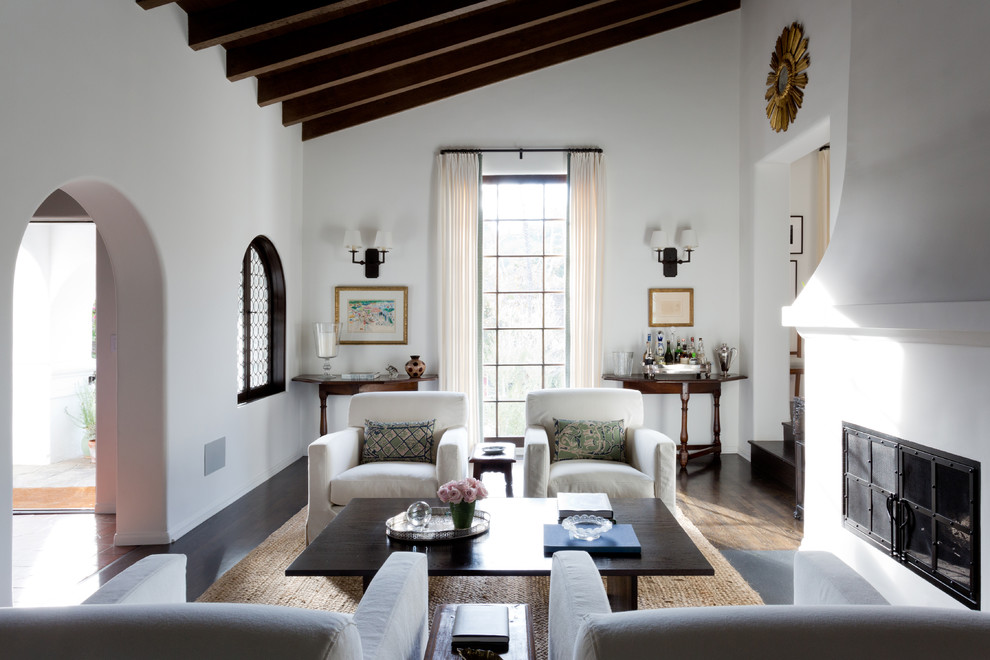 Ejemplo de salón para visitas cerrado mediterráneo con paredes blancas, suelo de madera oscura, chimenea lineal y cortinas