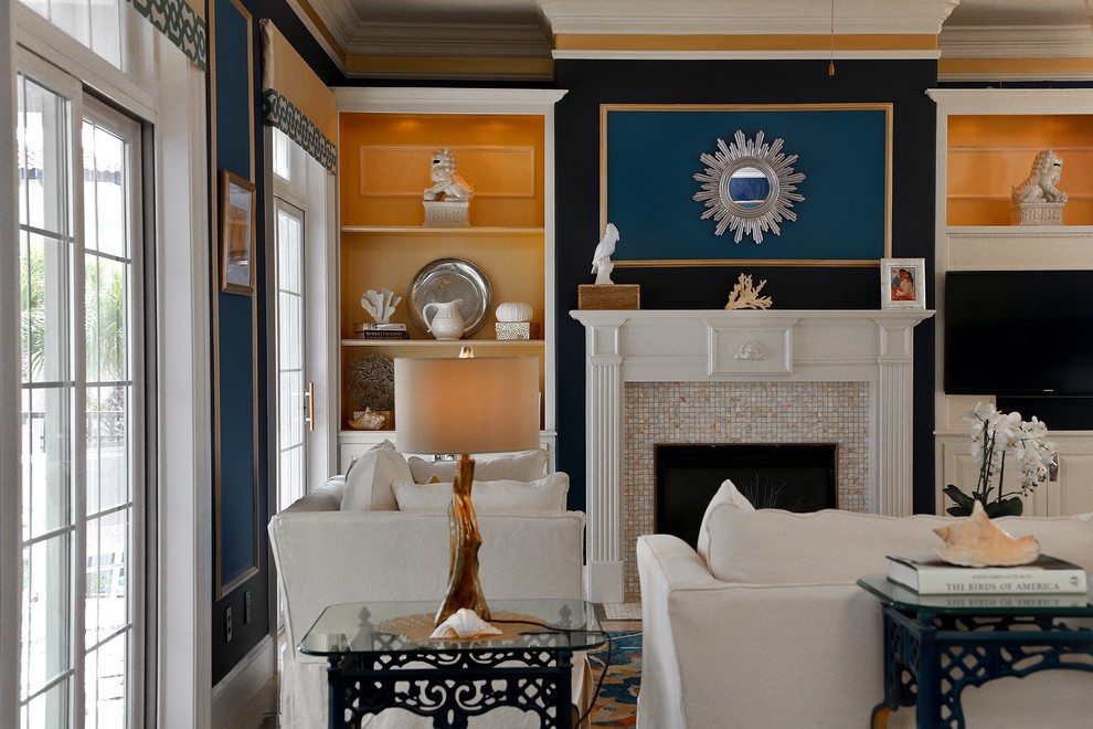 Cette image montre un grand salon marin ouvert avec une salle de réception, un mur bleu, un sol en carrelage de porcelaine, une cheminée standard, un manteau de cheminée en carrelage, un téléviseur fixé au mur et un sol beige.