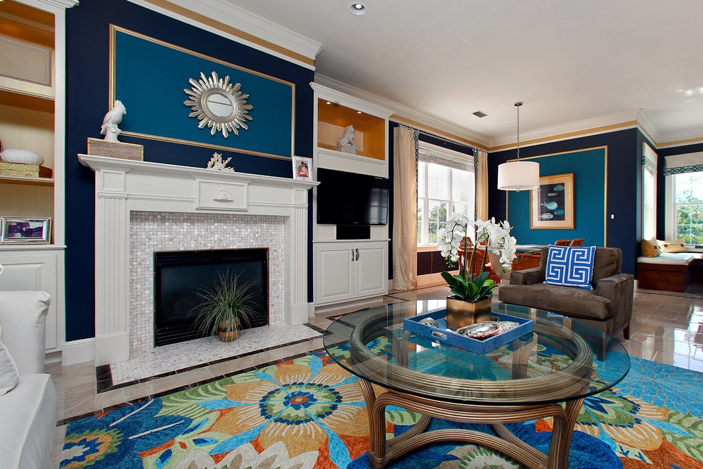 サンディエゴにある広いビーチスタイルのおしゃれなリビング (青い壁、磁器タイルの床、標準型暖炉、タイルの暖炉まわり、壁掛け型テレビ、ベージュの床) の写真