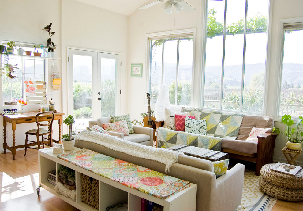 Living room - cottage medium tone wood floor living room idea in Santa Barbara with a music area and white walls