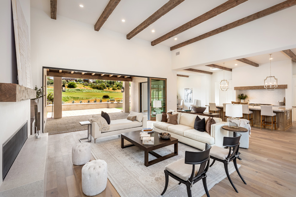This is an example of a rural open plan living room in San Diego with white walls, light hardwood flooring, a ribbon fireplace, beige floors and feature lighting.