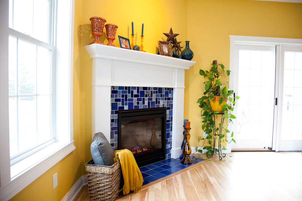 Großes, Offenes, Fernseherloses Eklektisches Wohnzimmer mit gelber Wandfarbe, braunem Holzboden, Eckkamin und gefliester Kaminumrandung in Minneapolis