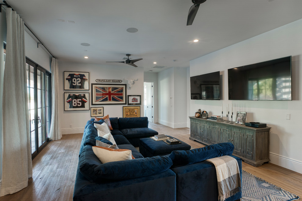 На фото: изолированная гостиная комната среднего размера в современном стиле с серыми стенами, паркетным полом среднего тона, телевизором на стене и коричневым полом без камина