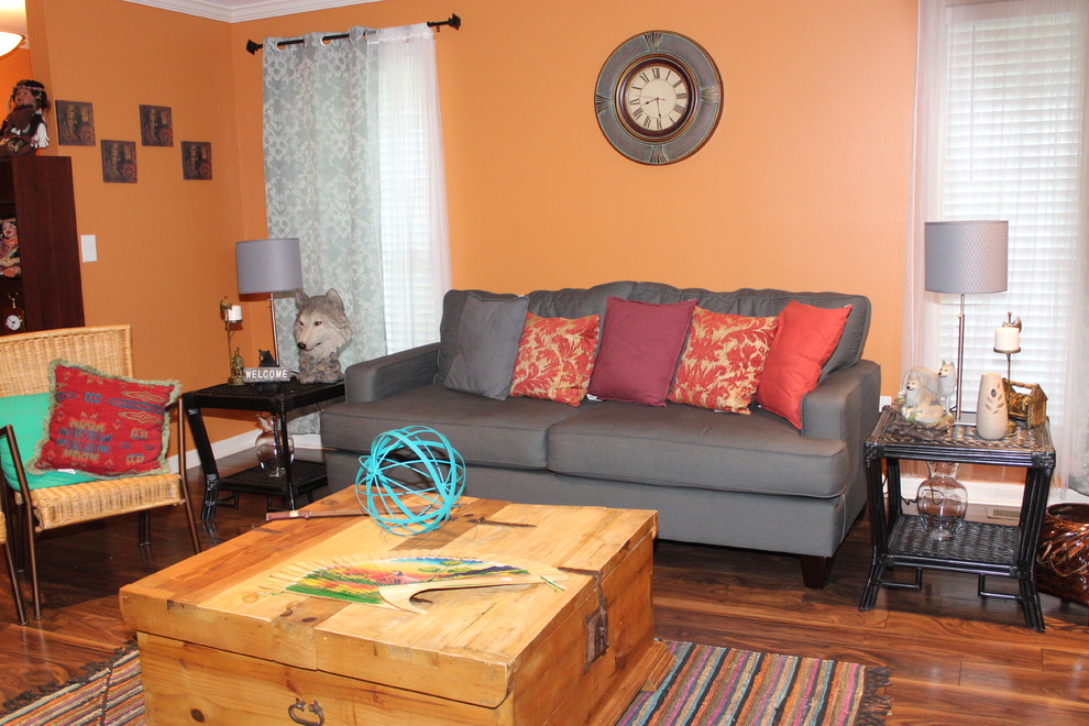 Foto på ett mellanstort amerikanskt separat vardagsrum, med orange väggar och mellanmörkt trägolv