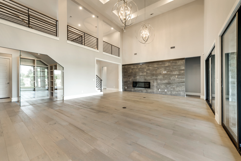 Large transitional open concept light wood floor living room photo in Dallas with beige walls, a standard fireplace, a tile fireplace and a wall-mounted tv
