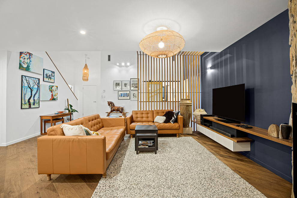 Mittelgroßes, Repräsentatives, Offenes Modernes Wohnzimmer mit weißer Wandfarbe, braunem Holzboden, Eckkamin, TV-Wand und gewölbter Decke in Sonstige