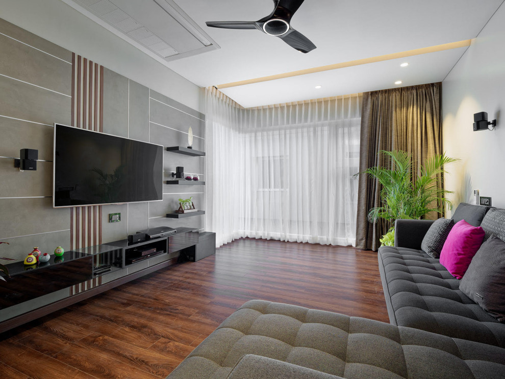 Cette image montre un salon design de taille moyenne et ouvert avec un mur gris, un téléviseur fixé au mur et un sol marron.