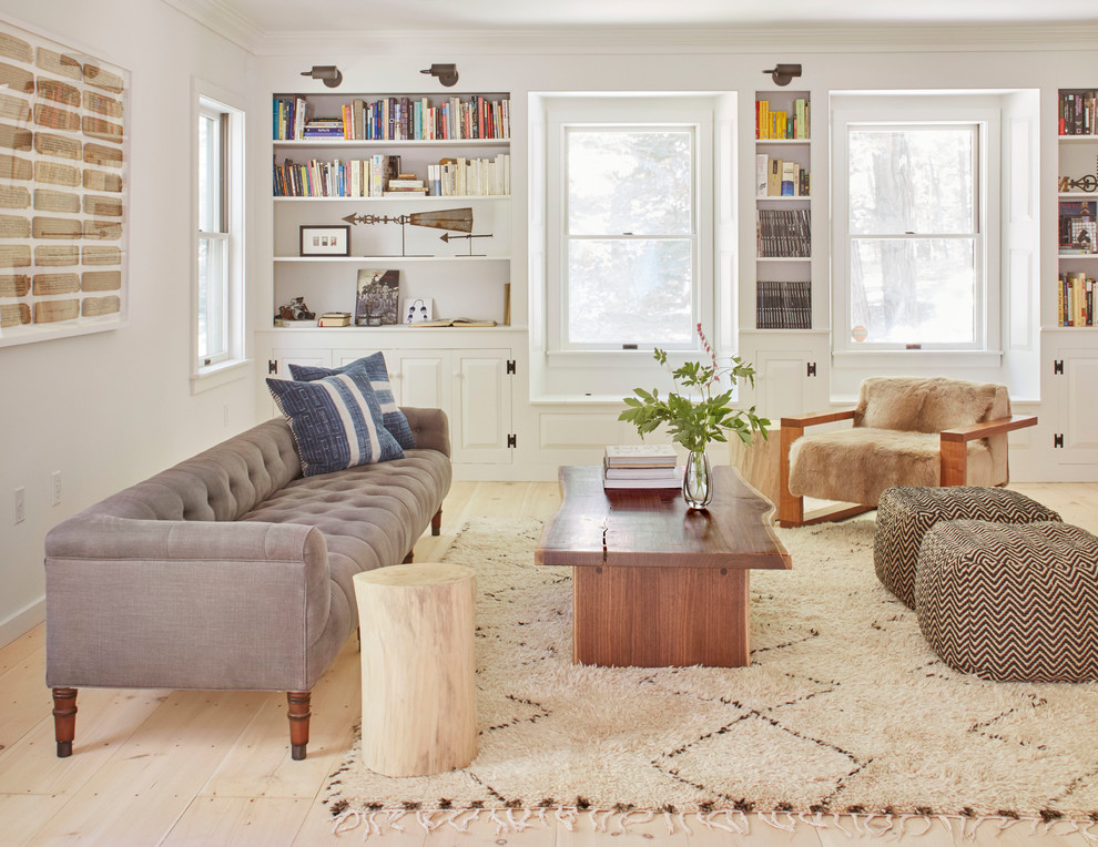 Esempio di un soggiorno classico con libreria, pareti bianche e parquet chiaro