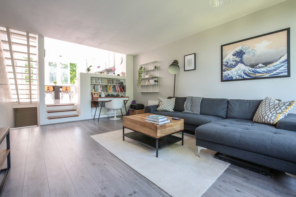 Imagen de salón abierto escandinavo pequeño con paredes grises, suelo laminado y suelo gris