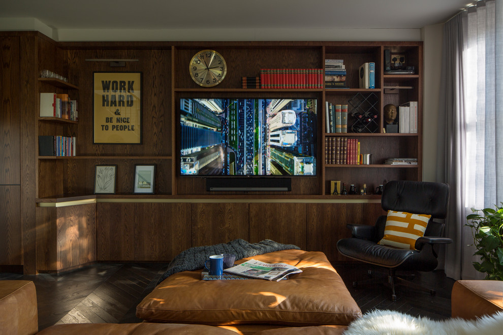 Nordisk inredning av ett mellanstort allrum med öppen planlösning, med ett bibliotek, bruna väggar, mörkt trägolv, en väggmonterad TV och brunt golv