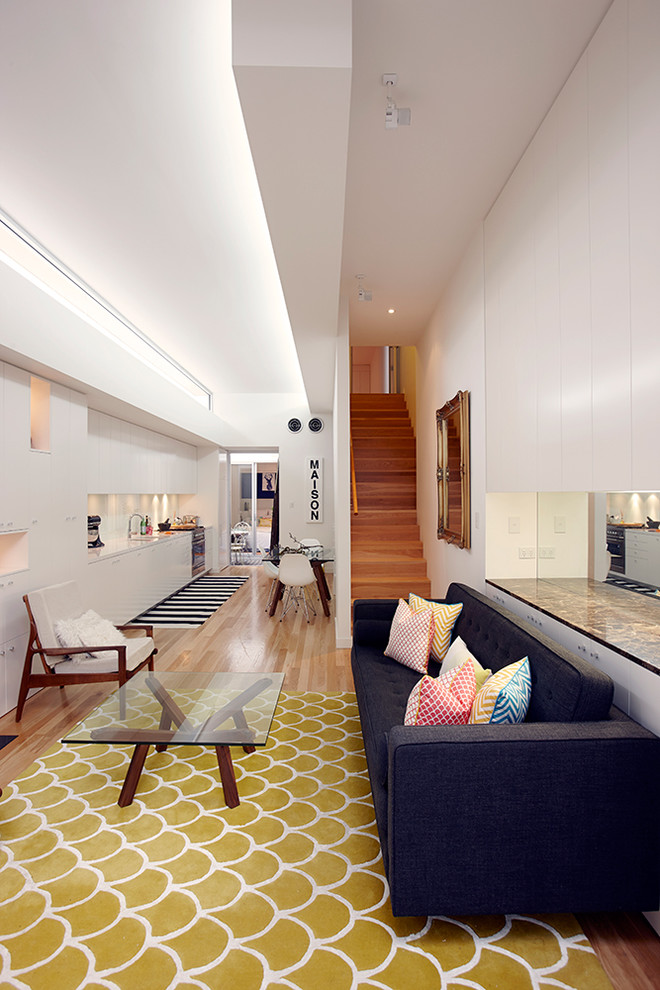 Photo of a small scandi open plan living room in Sydney with a reading nook, white walls and light hardwood flooring.