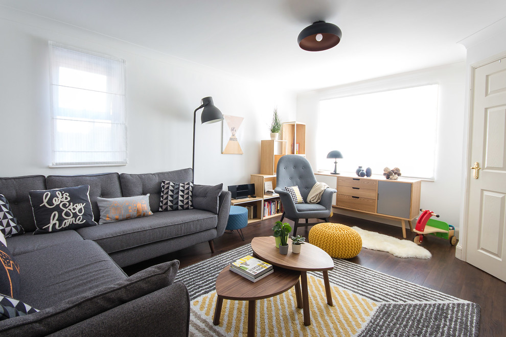 Ispirazione per un soggiorno scandinavo di medie dimensioni e chiuso con pareti bianche, pavimento in laminato, TV a parete e pavimento marrone