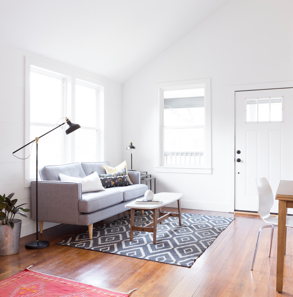 Small scandinavian open plan living room in Austin with white walls and medium hardwood flooring.