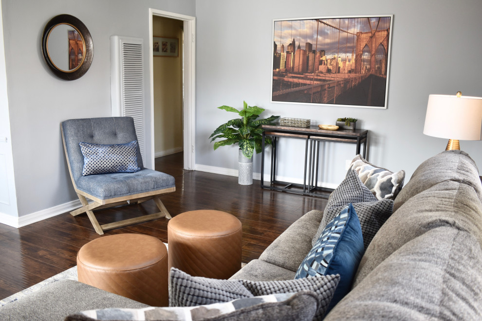 Mittelgroßes, Offenes Skandinavisches Wohnzimmer mit grauer Wandfarbe, dunklem Holzboden, freistehendem TV und braunem Boden in Los Angeles