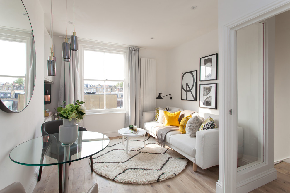 This is an example of a medium sized scandi enclosed living room in London with beige walls and a freestanding tv.